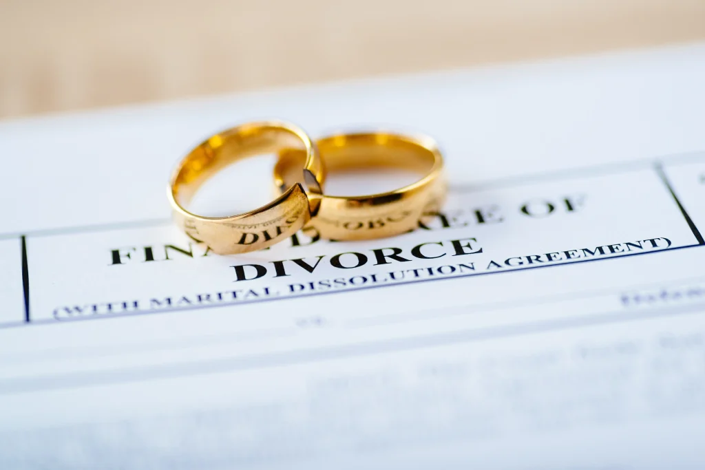 Two wedding rings sitting on top of divorce paperwork.