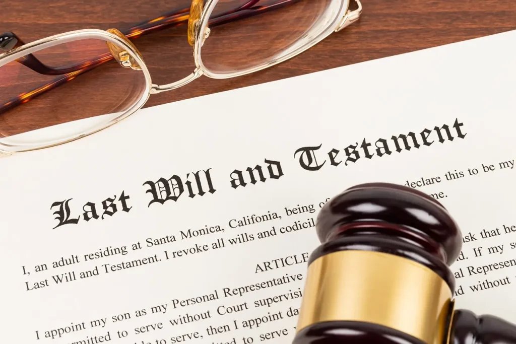 Paperwork that says last will and testament with glasses and a gavel.